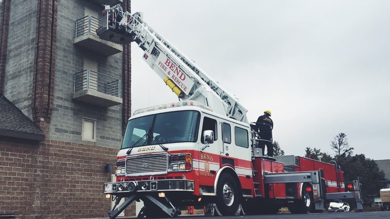 Bend Fire ladder truck with its aerial raised beside the training tower